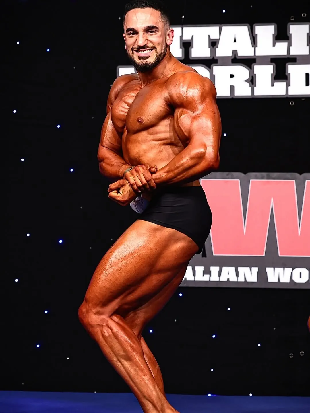 Pietro Salerno in posa di side chest sul palco dell'Italian World Cup IFBB